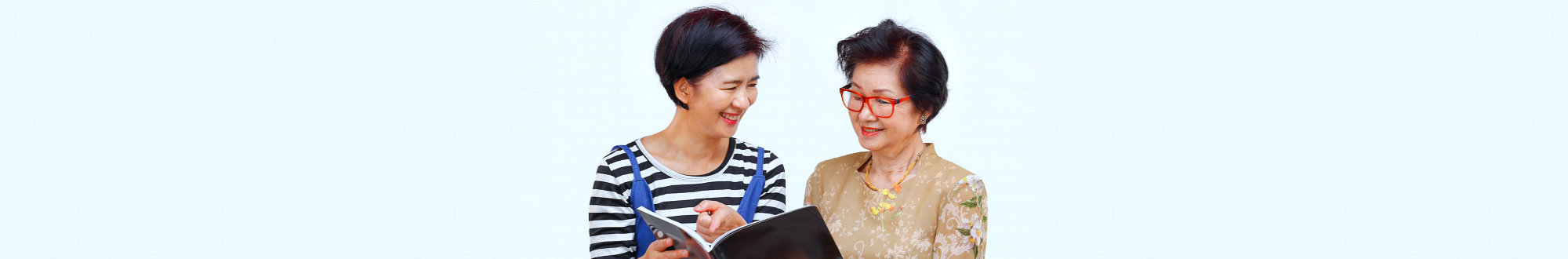 caregiver reading a book to a senior woman