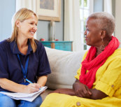 caregiver writing a report with a senior woman