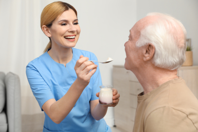 caregiver feeding a senior man